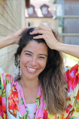 Mutlu genç kadın yaz elbisesi içinde poz veriyor.