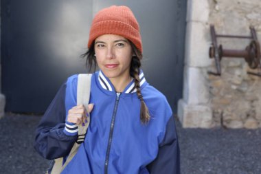 Sırt çantalı gülümseyen genç bir kadının portresi