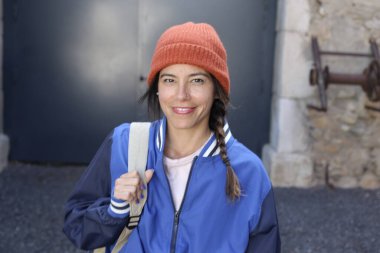 Sırt çantalı gülümseyen genç bir kadının portresi