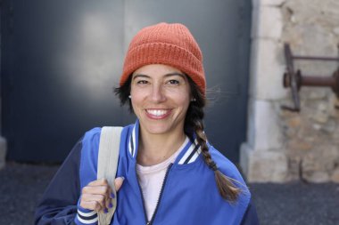 Sırt çantalı gülümseyen genç bir kadının portresi