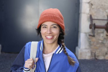 Sırt çantalı gülümseyen genç bir kadının portresi