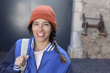 Sırt çantalı gülümseyen genç bir kadının portresi