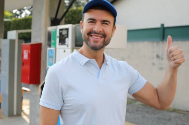 Genç İspanyol üniformalı adam istasyonda mutlu bir şekilde gülümsüyor..