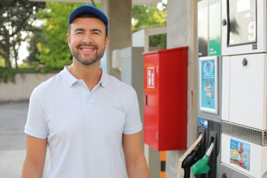 Genç İspanyol üniformalı adam istasyonda mutlu bir şekilde gülümsüyor..