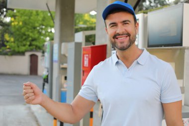 Genç İspanyol üniformalı adam istasyonda mutlu bir şekilde gülümsüyor..