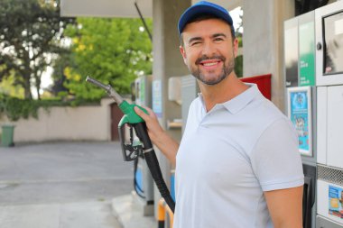 Genç İspanyol üniformalı adam istasyonda mutlu bir şekilde gülümsüyor..