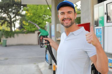 Genç İspanyol üniformalı adam istasyonda mutlu bir şekilde gülümsüyor..