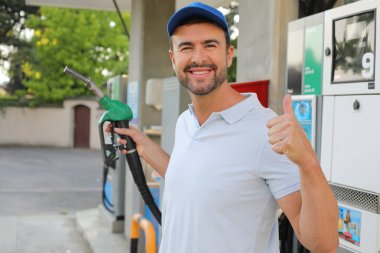 Genç İspanyol üniformalı adam istasyonda mutlu bir şekilde gülümsüyor..