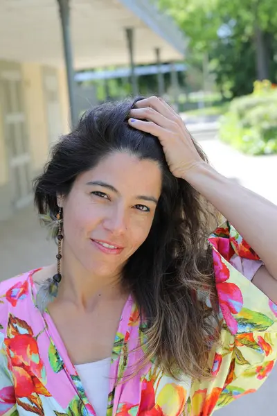 Mutlu genç kadın yaz elbisesi içinde poz veriyor.