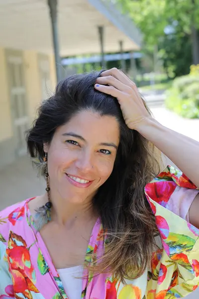 Mutlu genç kadın yaz elbisesi içinde poz veriyor.