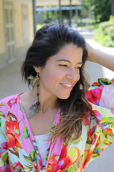 Mutlu genç kadın yaz elbisesi içinde poz veriyor.