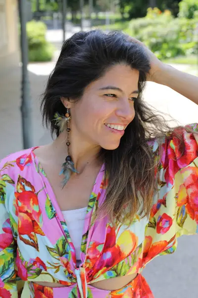 Mutlu genç kadın yaz elbisesi içinde poz veriyor.