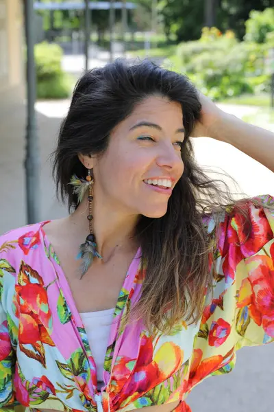 Mutlu genç kadın yaz elbisesi içinde poz veriyor.