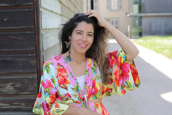 Mutlu genç kadın yaz elbisesi içinde poz veriyor.