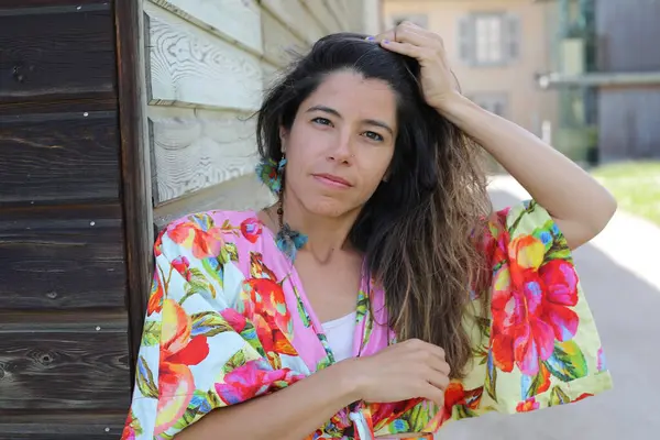 Mutlu genç kadın yaz elbisesi içinde poz veriyor.