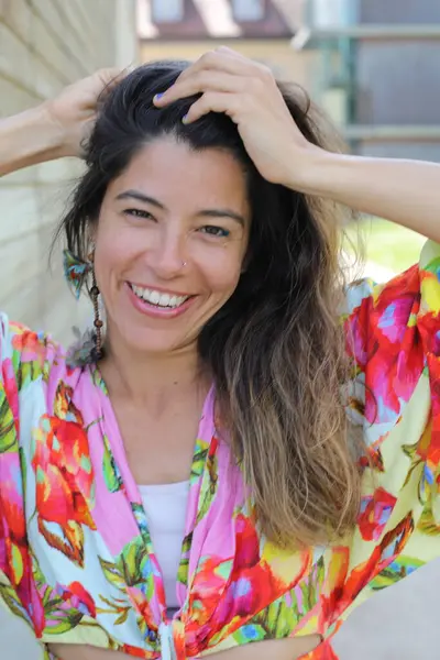 Mutlu genç kadın yaz elbisesi içinde poz veriyor.