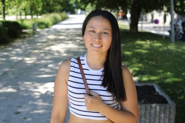 İspanyol kadın gülümsüyor ve parkta kameraya bakıyor.