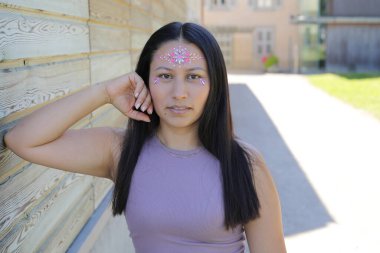 Yüzünde parlak taşlar olan eğlenceli bir kadın. 