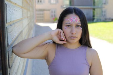 Yüzünde parlak taşlar olan eğlenceli bir kadın. 