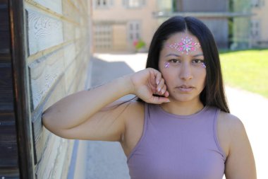 Yüzünde parlak taşlar olan eğlenceli bir kadın. 