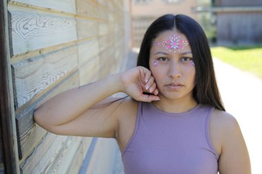 Yüzünde parlak taşlar olan eğlenceli bir kadın. 