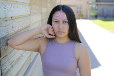 Yüzünde parlak taşlar olan eğlenceli bir kadın. 