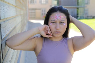 Yüzünde parlak taşlar olan eğlenceli bir kadın. 