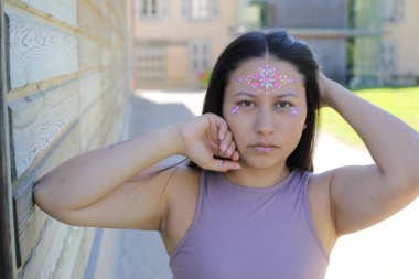 Yüzünde parlak taşlar olan eğlenceli bir kadın. 