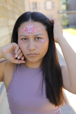 Yüzünde parlak taşlar olan eğlenceli bir kadın. 