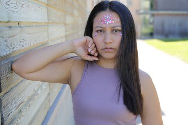 Yüzünde parlak taşlar olan eğlenceli bir kadın. 