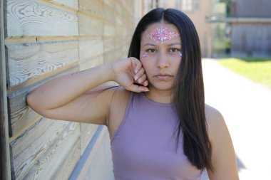 Yüzünde parlak taşlar olan eğlenceli bir kadın. 