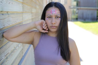 Yüzünde parlak taşlar olan eğlenceli bir kadın. 