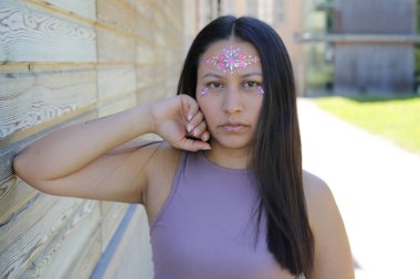 Yüzünde parlak taşlar olan eğlenceli bir kadın. 