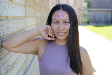 Yüzünde parlak taşlar olan eğlenceli bir kadın. 