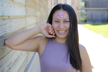 Yüzünde parlak taşlar olan eğlenceli bir kadın. 