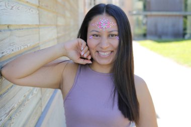 Yüzünde parlak taşlar olan eğlenceli bir kadın. 