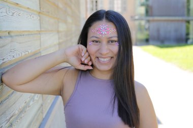 Yüzünde parlak taşlar olan eğlenceli bir kadın. 