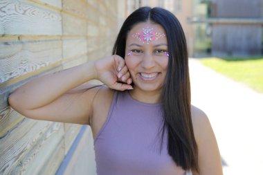 Yüzünde parlak taşlar olan eğlenceli bir kadın. 