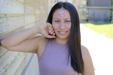 Yüzünde parlak taşlar olan eğlenceli bir kadın. 