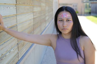 Yüzünde parlak taşlar olan eğlenceli bir kadın. 