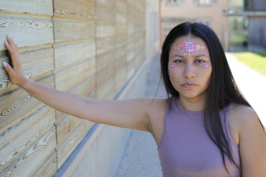 Yüzünde parlak taşlar olan eğlenceli bir kadın. 