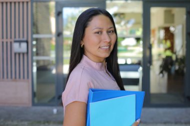 Güzel Latin Amerikalı iş kadını dışarıda gülümsüyor.