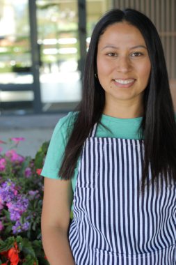 Yüzünde gülümseme olan genç Latin bir kadın.