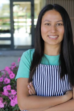 Yüzünde gülümseme olan genç Latin bir kadın.