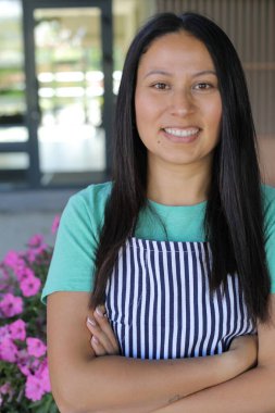 Yüzünde gülümseme olan genç Latin bir kadın.