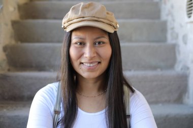 Pantolon askısı ve klasik şapka takan bir kadın. 