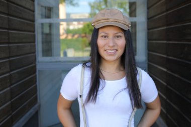 Pantolon askısı ve klasik şapka takan bir kadın. 