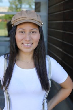 Pantolon askısı ve klasik şapka takan bir kadın. 