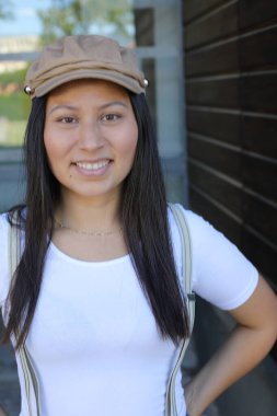 Pantolon askısı ve klasik şapka takan bir kadın. 