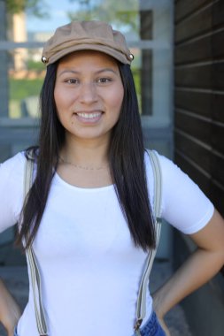 Pantolon askısı ve klasik şapka takan bir kadın. 